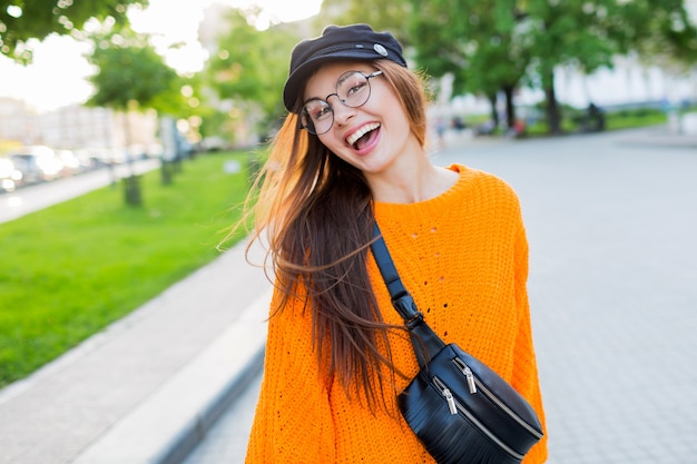 Lifestyle  portrait of  beautiful woman with amazing long brunette windy hairs enjoying walk in park.