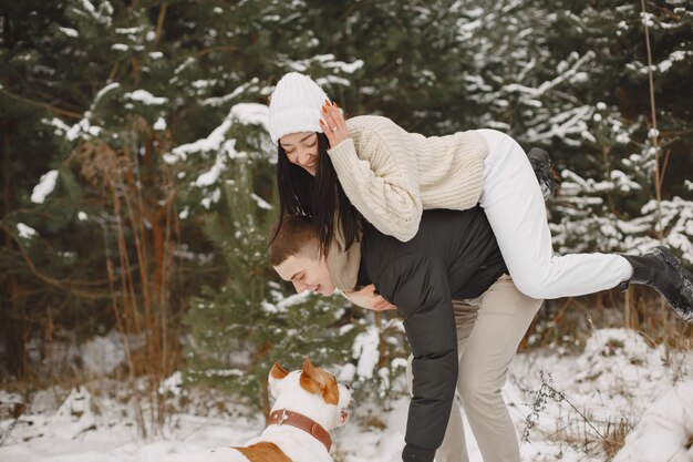 犬と雪の森でカップルのライフスタイルショット