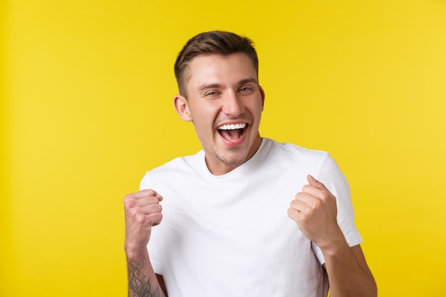 Lifestyle, summer and people emotions concept. Close-up portrait of rejoicing handsome happy guy jumping from delight, winning lottery or prize, chanting and laughing over success.