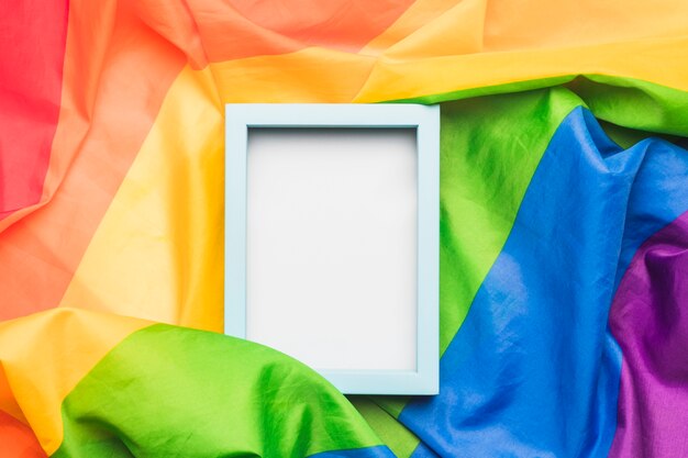 Голубая пустая рамка на мятом флаге ЛГБТ