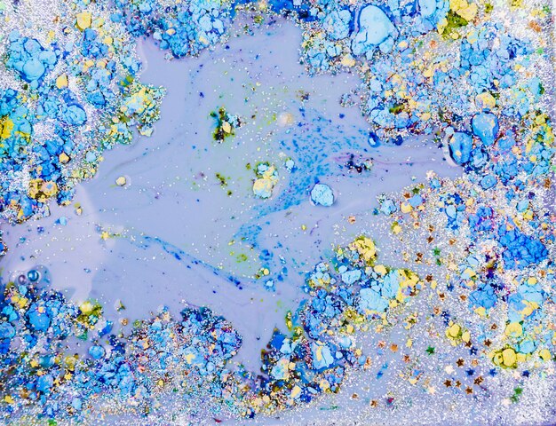 Light blue liquid mixing with ornamental stars and bright crumbs