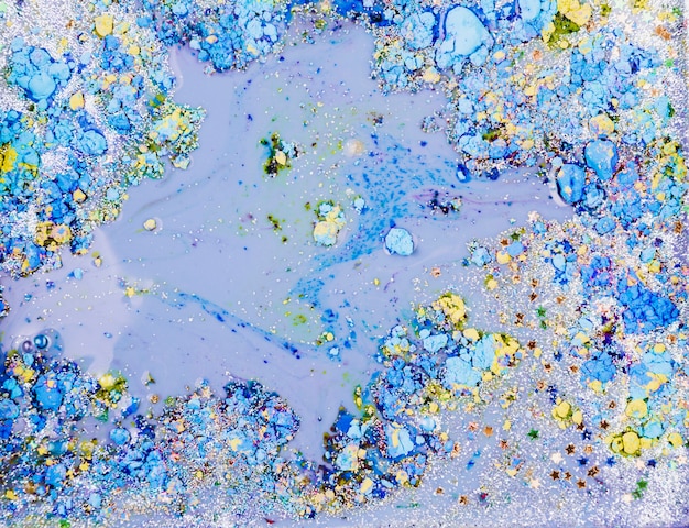 Light blue liquid mixing with ornamental stars and bright crumbs