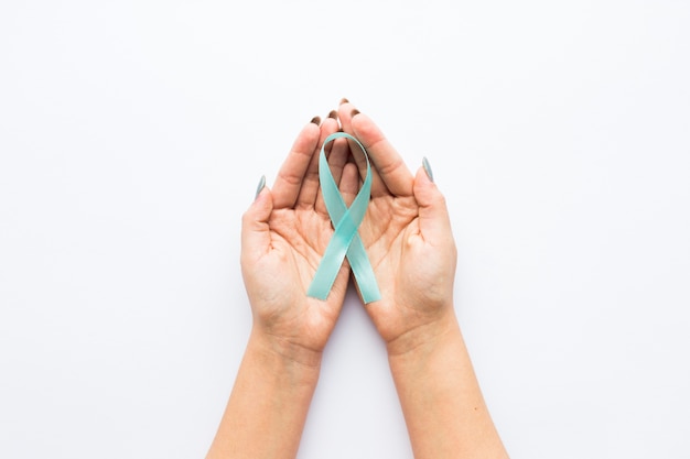 Light blue ribbon on crop hands