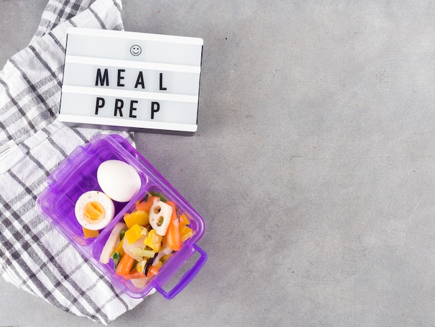 Light board with meal prep inscription near food in container