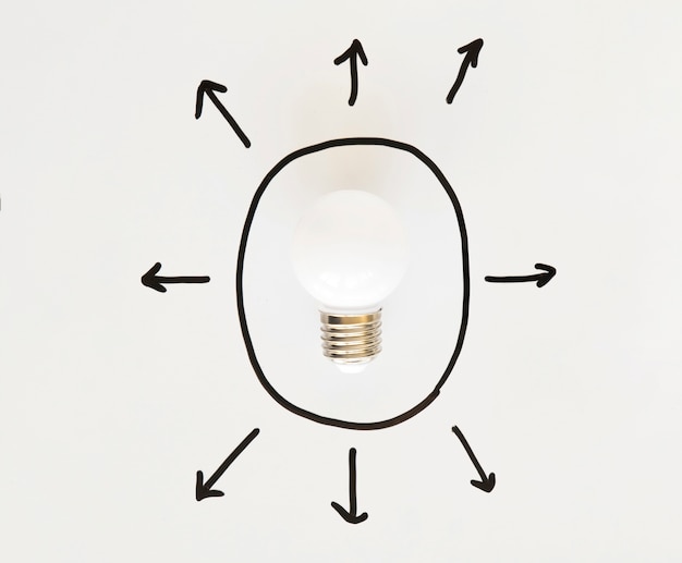 Foto gratuita lampadina dentro forma ovale disegnata a mano con vari simboli freccia