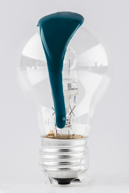 Light bulb with dripping green paint