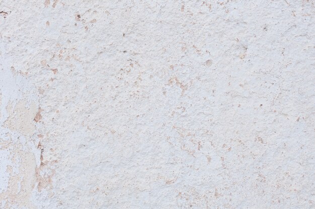 Light colored plaster wall with flakes