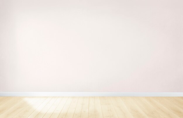 Light pink wall in an empty room with a wooden floor