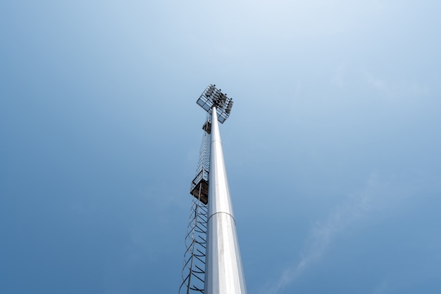 Free photo light pole tower in sport arena on blue sky