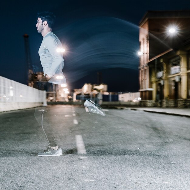 Light silhouette of sportsman running on street