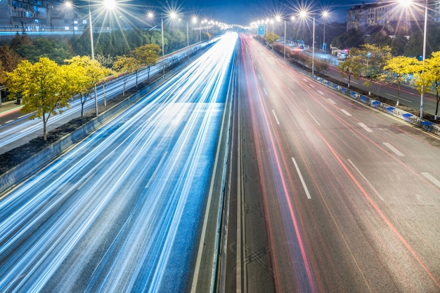 light trails on city street with cityscape