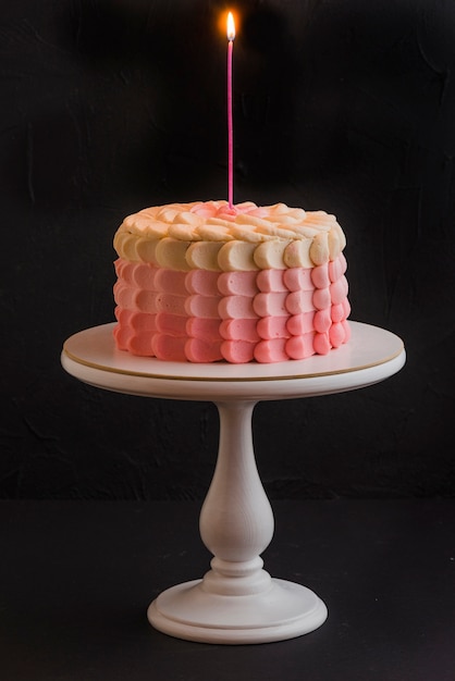 Free photo lighted candle on decorative creamy cake