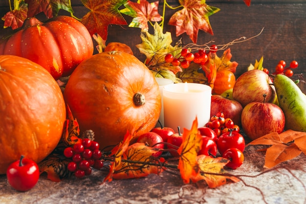 Lighted candles among autumnal harvest