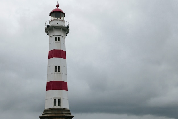 Free photo lighthouse against dark overcast sky