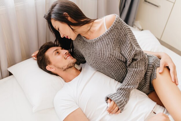 lightly-tanned woman with black hair having fun with husband in sunday morning