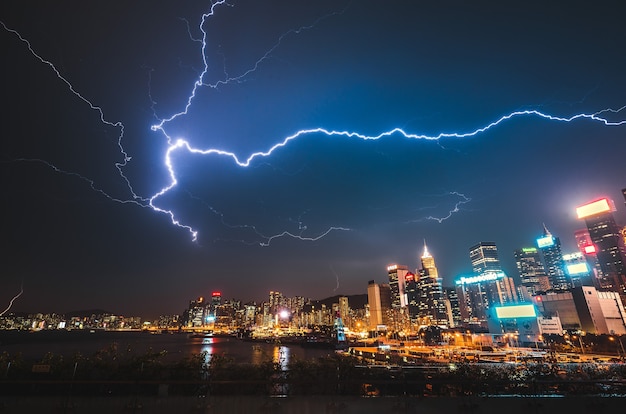 夜の近代的な都市への落雷