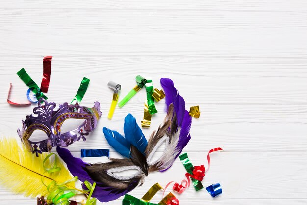 Lilac and feather masks on confetti