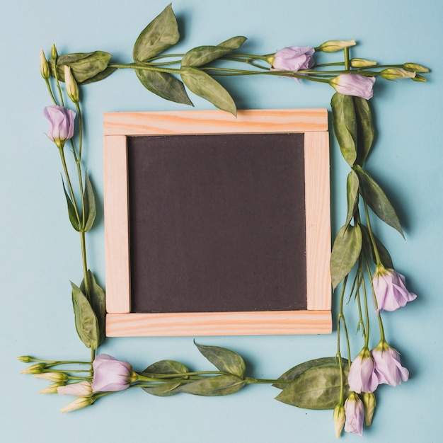 Lilac roses around empty blackboard