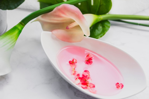 Lily near bowl with essential oil