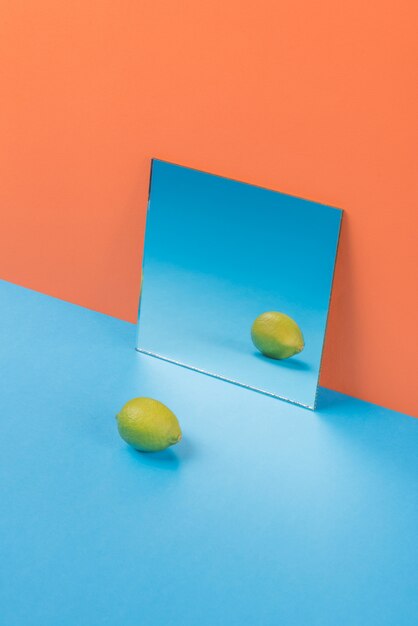 オレンジに分離された青いテーブルにライムします。