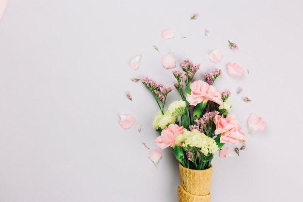 Limonium and carnations flowers in the waffle cones isolated on white background