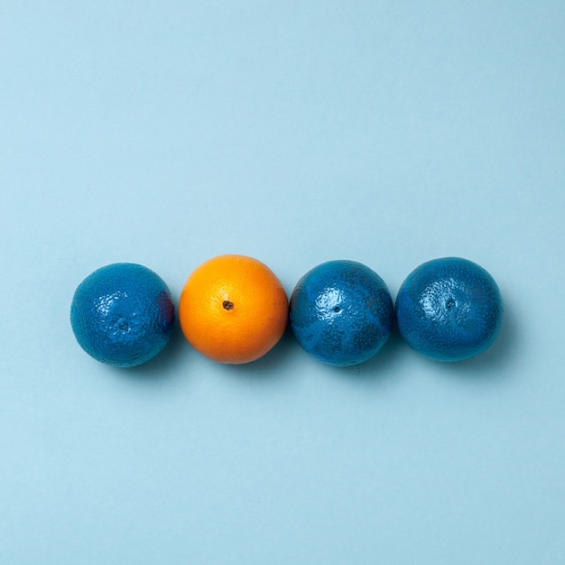 Free photo line of blue oranges with one clean orange