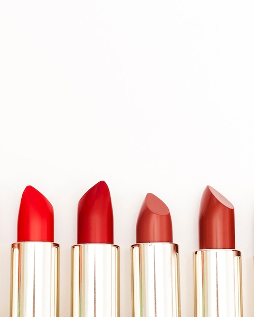 Line of metallic lipsticks on white background