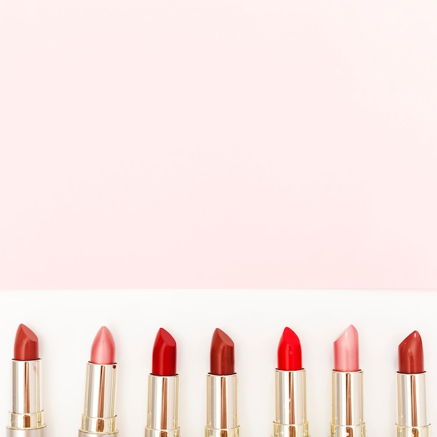 Line of metallic lipsticks on white background