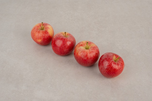 Line of red apples on white background .