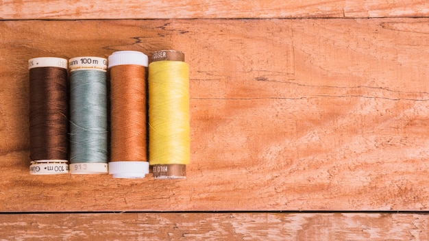 Line of reel of yarn on wooden background