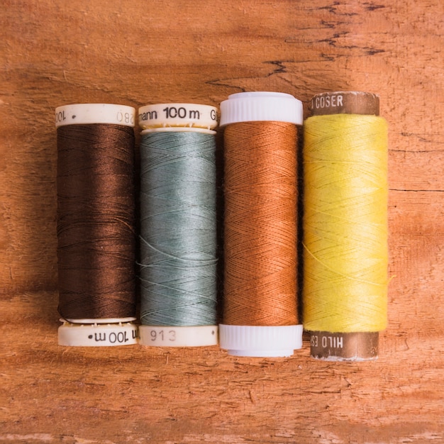 Line of reel of yarn on wooden background