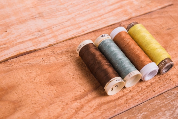 Line of reel of yarn on wooden background
