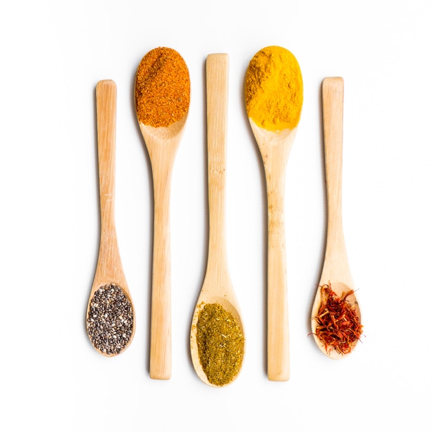 Line of wooden spoons full of spices