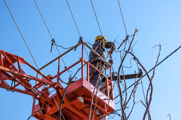 Lineman duty working fix power line on electrical cable with aerial work platforms