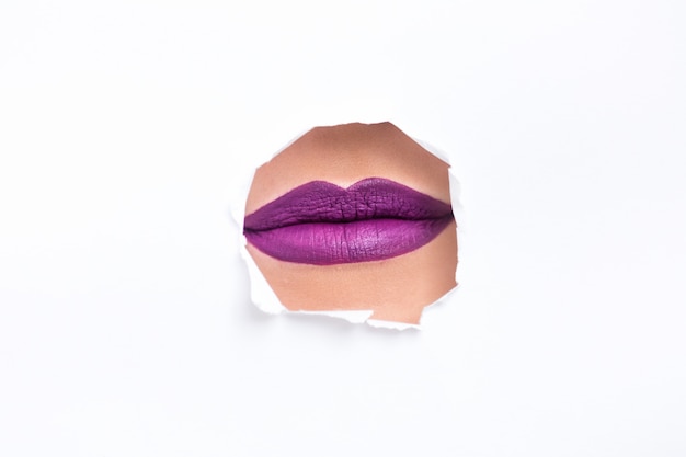 Free photo lips with purple lipstick on a white wall