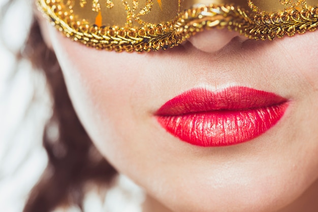 Free photo lips of woman with golden mask