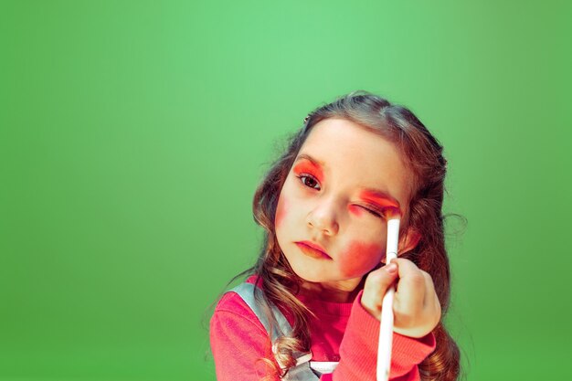 Lipstick. Little girl dreaming about profession of makeup artist. Childhood, planning, education and dream concept. Wants to become successful employee in fashion and style industry, hairstyle artist.