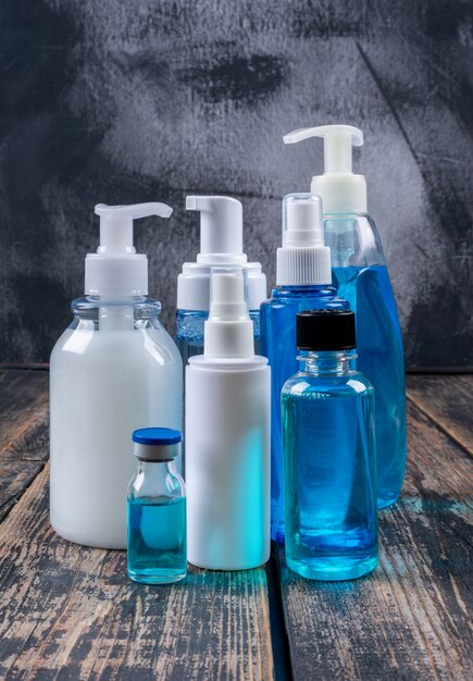Liquid soaps and sprays side view on a dark wooden background