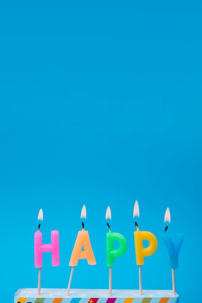Lit colorful candles with blue background