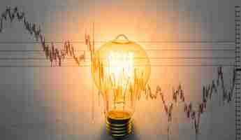 Free photo lit light bulb with graph background