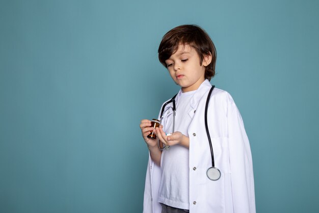 Litte child boy cute adorable sweet in white medical suit on blue wall