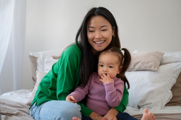 Little asian girl spending time at home with her mother