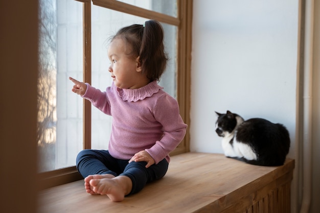 Little asian girl spending time at home with her pet cat