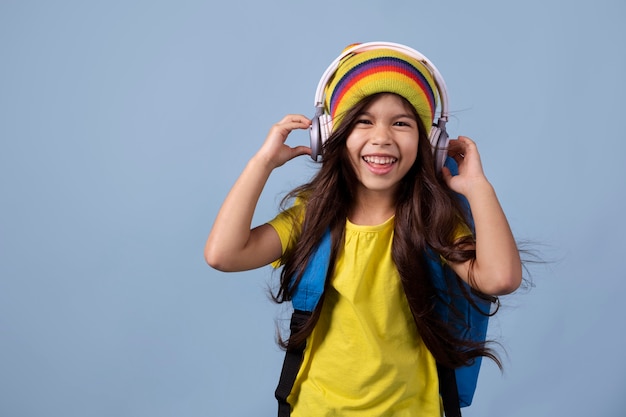 Free photo little asian school girl listening to music on headphones