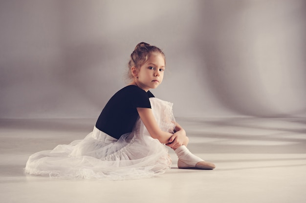 Free photo the little balerina dancer on gray wall