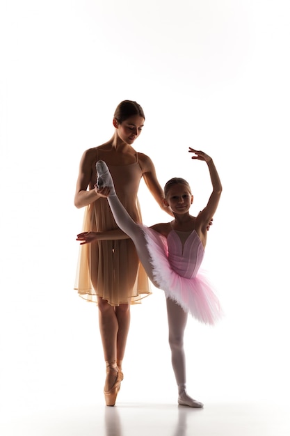 Free photo little ballerina dancing with personal ballet teacher in dance studio