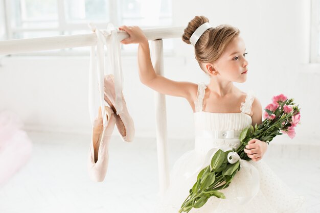 Маленькая балерина девушка в пачке. Прелестный ребенок танцует классический балет в белой студии.