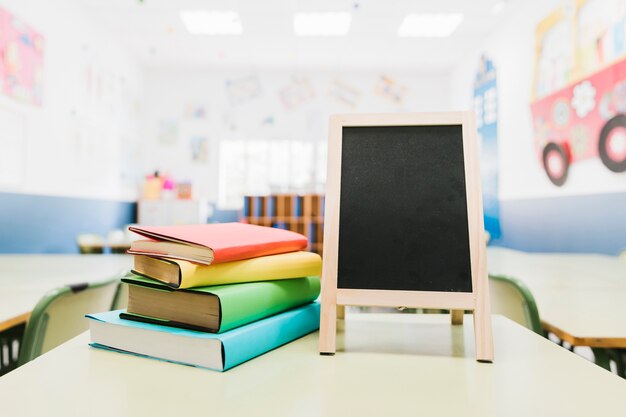 Little blackboard and textbooks on table