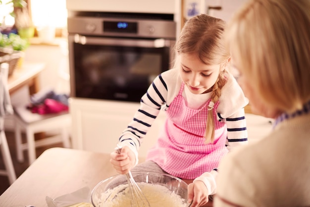 Free photo little blond girl mixing batter