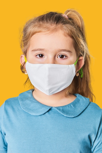 Free photo little blonde girl wearing face mask